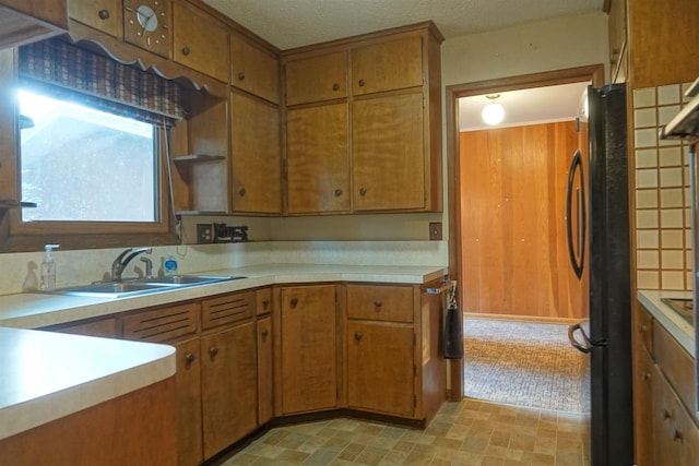 kitchen featuring a textured ceiling, refrigerator, and sink