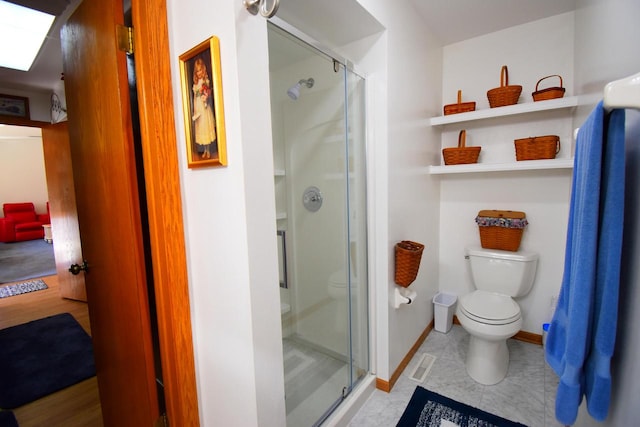 bathroom with tile patterned flooring, toilet, a skylight, and an enclosed shower