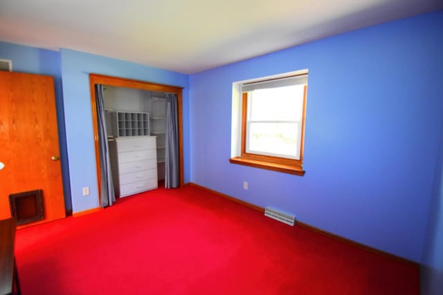 unfurnished bedroom featuring carpet and a closet