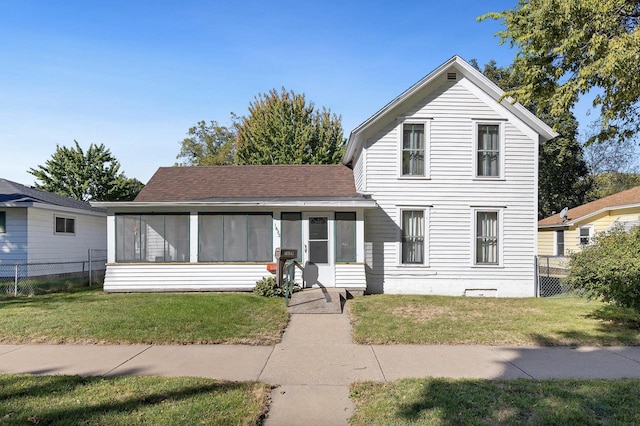 view of front of home featuring a sunroom and a front lawn