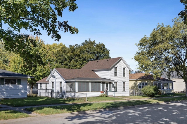 view of front of home featuring a sunroom and a front yard