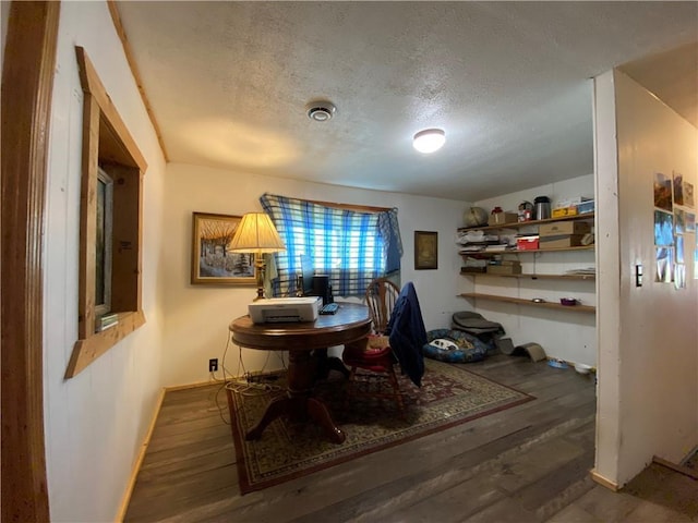 dining space with a textured ceiling and dark wood-type flooring