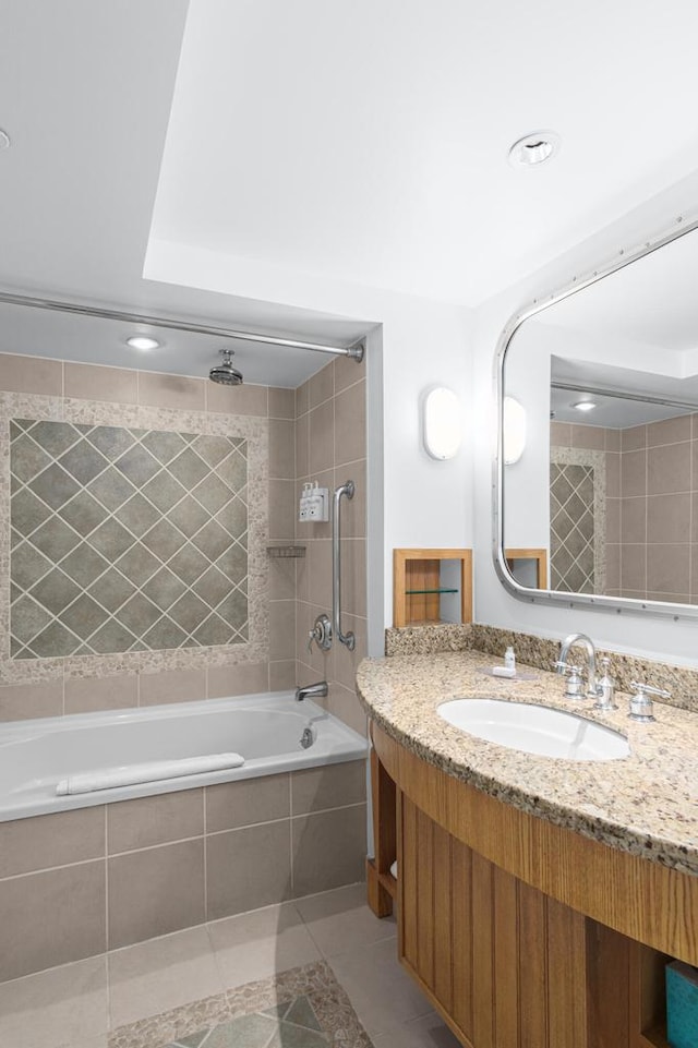 bathroom with tile patterned flooring, tiled shower / bath, and vanity