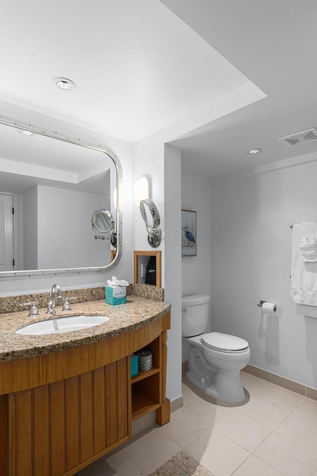 bathroom with vanity, toilet, and tile patterned floors