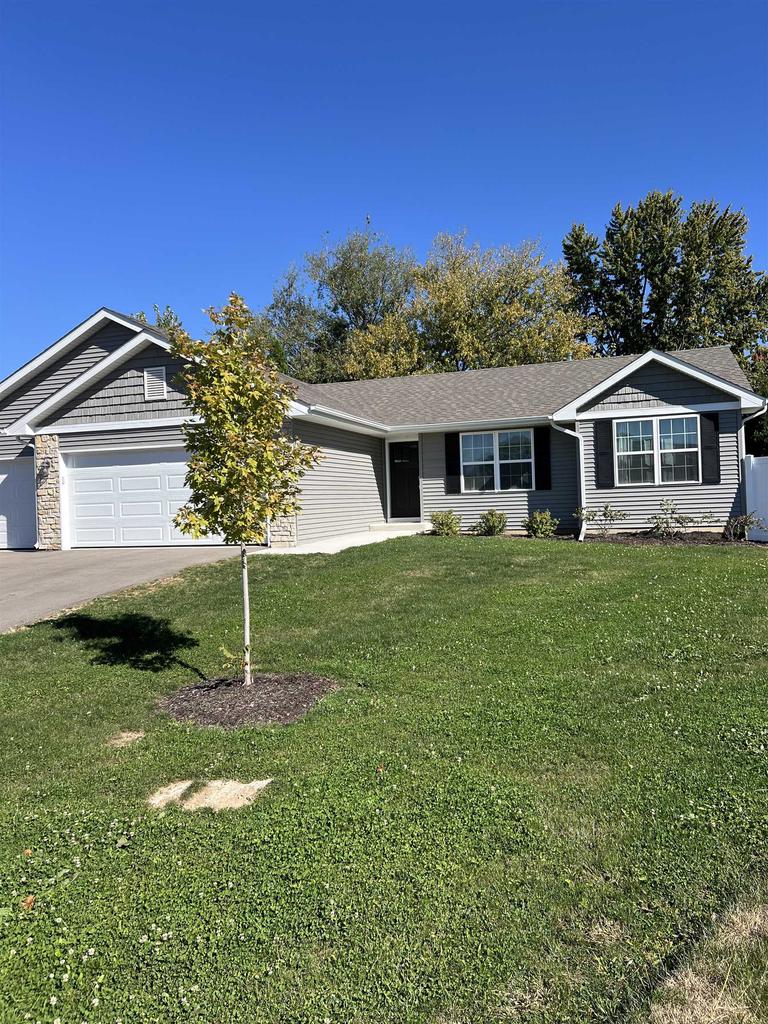 ranch-style home with a front lawn and a garage