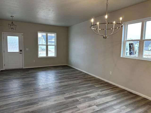 unfurnished dining area with an inviting chandelier and dark wood-type flooring