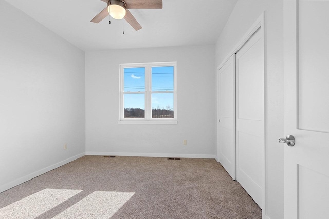 unfurnished bedroom with ceiling fan, carpet floors, and a closet