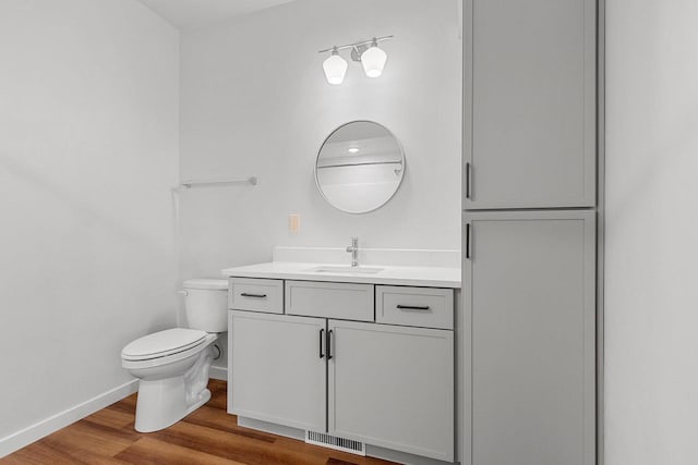 bathroom featuring vanity, hardwood / wood-style flooring, and toilet