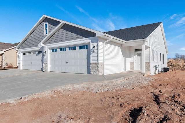 view of front facade featuring central AC unit and a garage