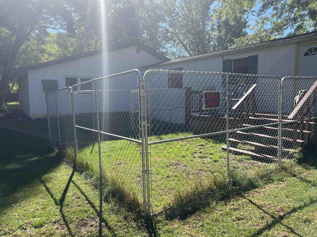 650 Roosevelt St, Mauston, WI 53948 - view of side of property featuring a lawn, a gate, and fence