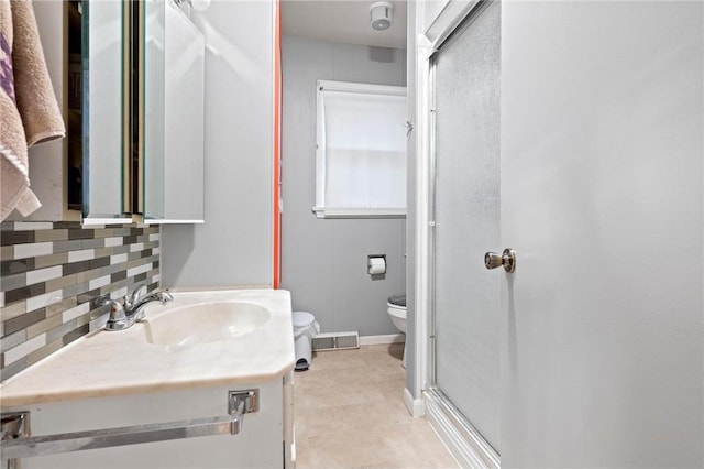 bathroom featuring tile patterned floors, decorative backsplash, toilet, vanity, and walk in shower