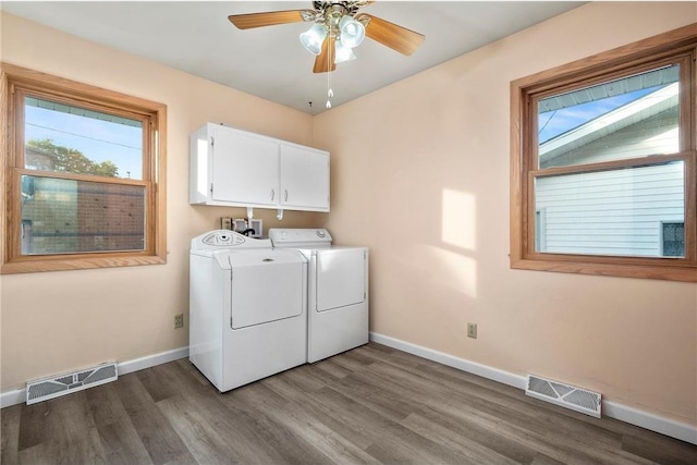 laundry area featuring dark wood-type flooring, ceiling fan, washing machine and dryer, and cabinets