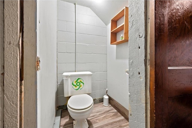 bathroom with hardwood / wood-style floors, vaulted ceiling, and toilet