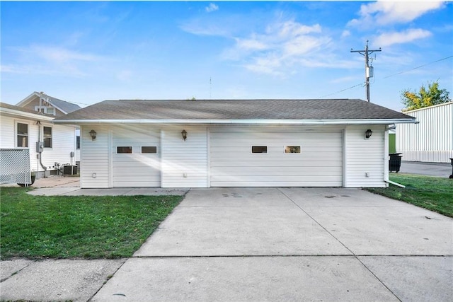 back of house with cooling unit, a yard, and a garage