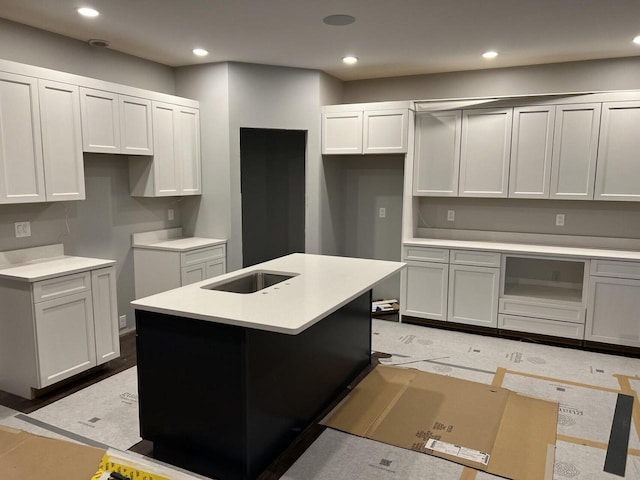 kitchen featuring white cabinetry and a center island with sink