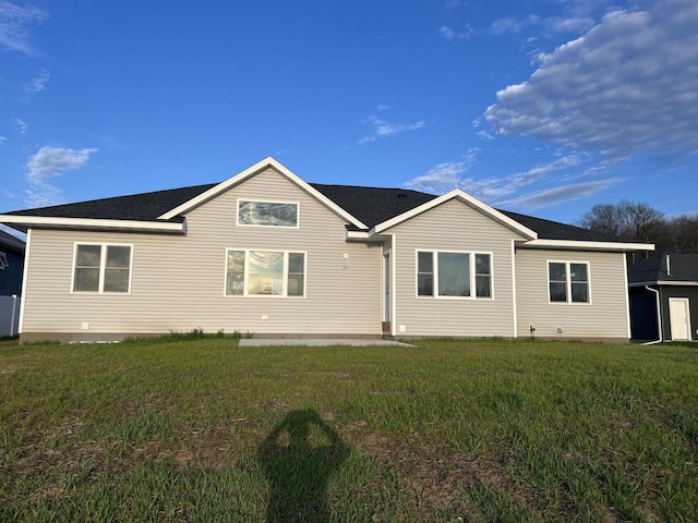 rear view of house featuring a lawn