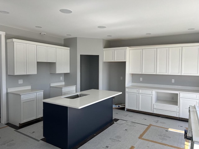 kitchen with white cabinets, sink, and a kitchen island