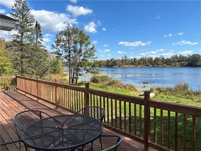 wooden terrace featuring a water view and a yard