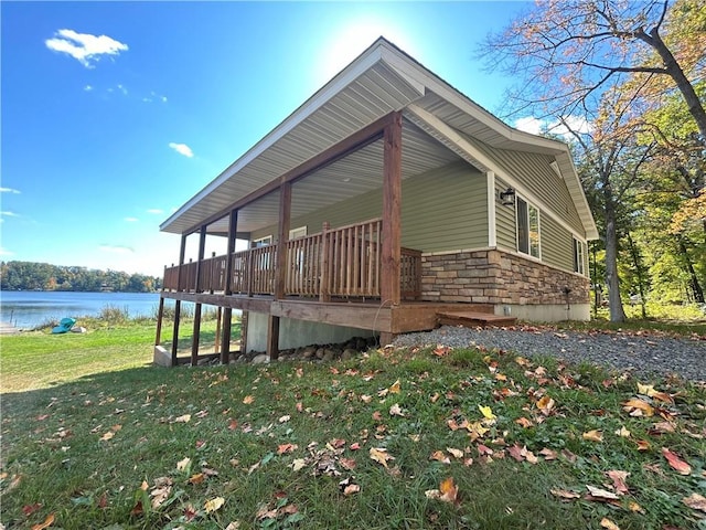 view of side of home featuring a yard and a deck with water view