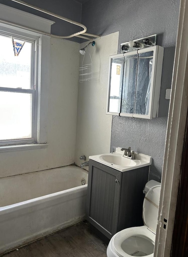 full bathroom featuring hardwood / wood-style flooring, shower / bath combination, vanity, and toilet