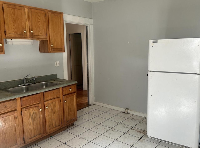 kitchen featuring light tile patterned flooring, sink, and white fridge