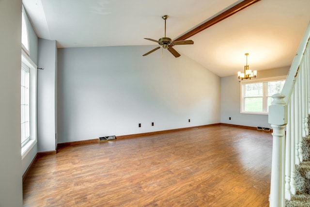 unfurnished living room featuring hardwood / wood-style flooring, ceiling fan with notable chandelier, plenty of natural light, and high vaulted ceiling