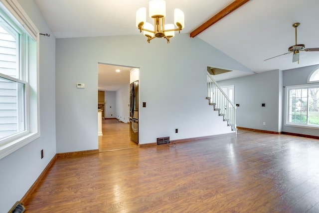 empty room featuring hardwood / wood-style flooring, vaulted ceiling with beams, and ceiling fan with notable chandelier