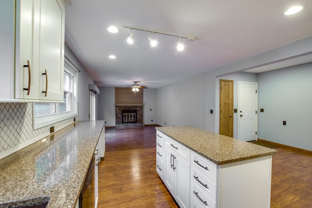 kitchen featuring light stone countertops, dark hardwood / wood-style floors, and a fireplace