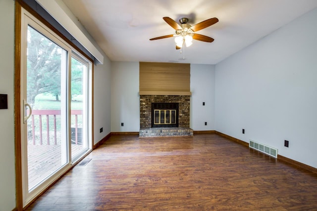 unfurnished living room with a fireplace, dark hardwood / wood-style floors, and ceiling fan