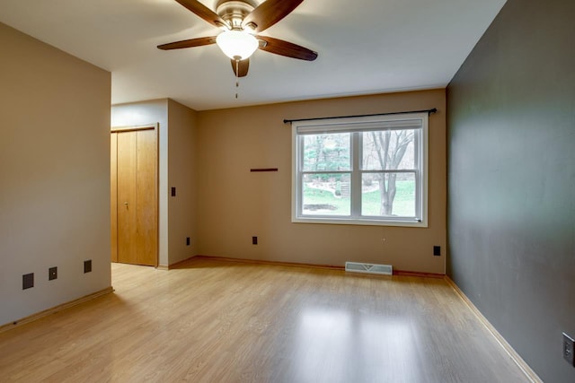 spare room featuring light wood-type flooring and ceiling fan