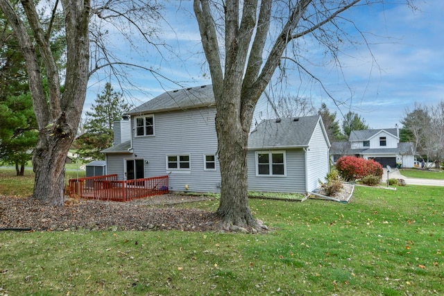 rear view of house featuring a lawn and a deck