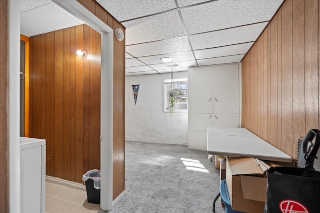 office featuring a paneled ceiling, washer / clothes dryer, and wooden walls