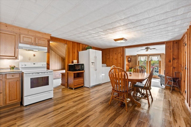 kitchen featuring wooden walls, ceiling fan, independent washer and dryer, white appliances, and light hardwood / wood-style floors