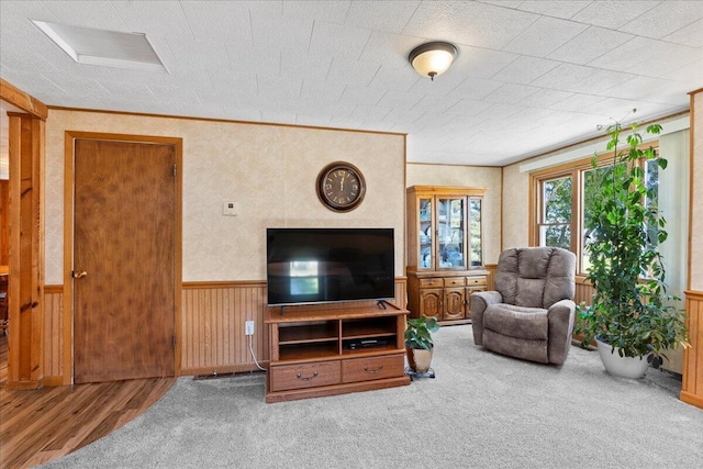 living room with wood walls, hardwood / wood-style floors, and a textured ceiling