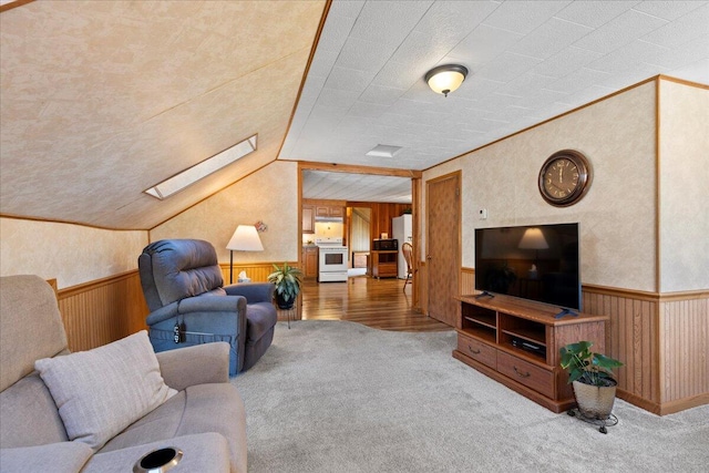 living room with wooden walls, wood-type flooring, and vaulted ceiling with skylight