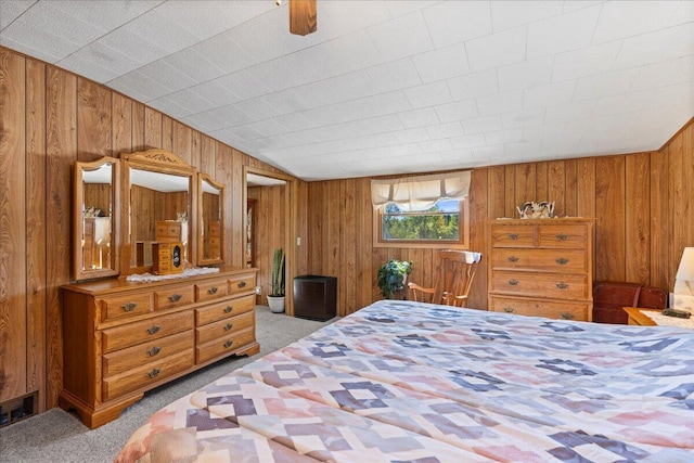 carpeted bedroom featuring wood walls