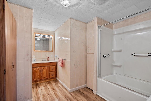 bathroom with hardwood / wood-style flooring, vanity, and shower / washtub combination