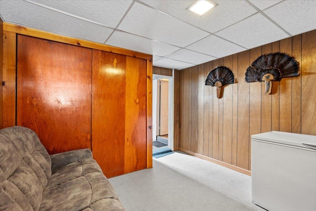 living room with wood walls and a paneled ceiling