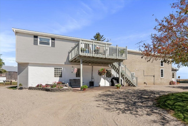 back of property featuring cooling unit and a wooden deck