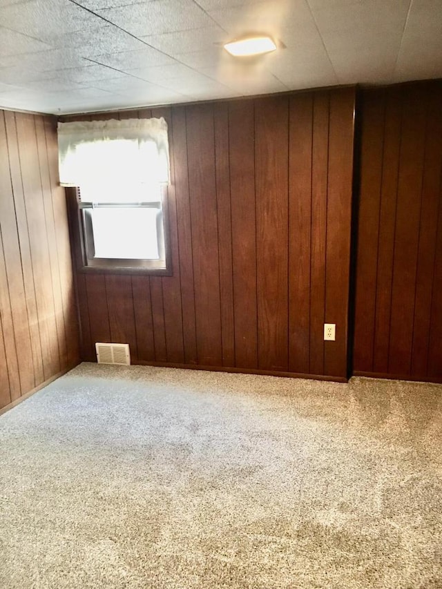 unfurnished room with carpet floors and wooden walls