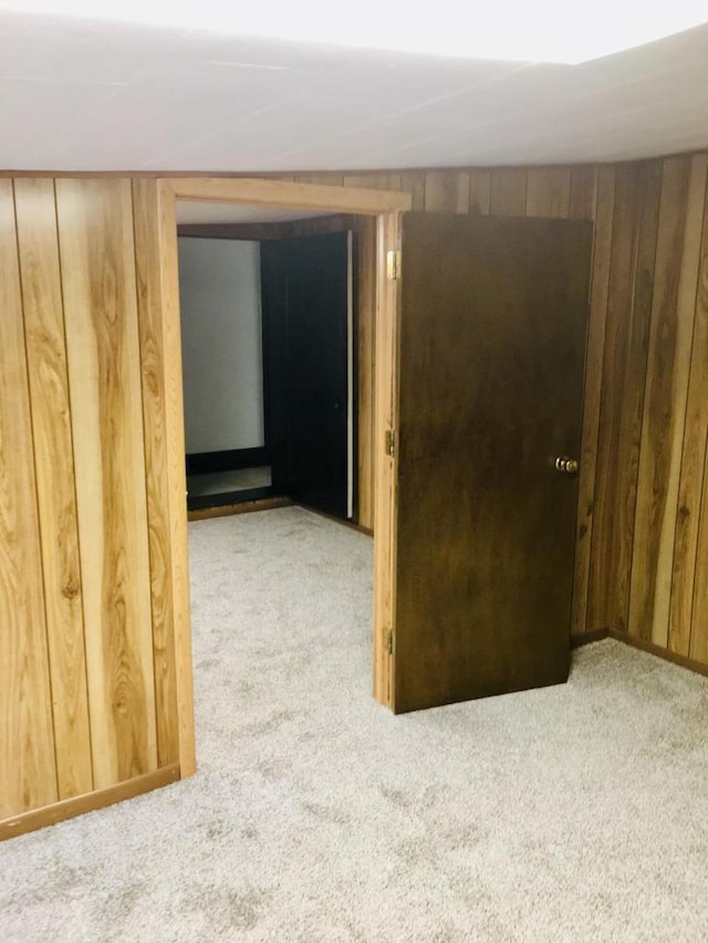 hallway with light carpet and wooden walls