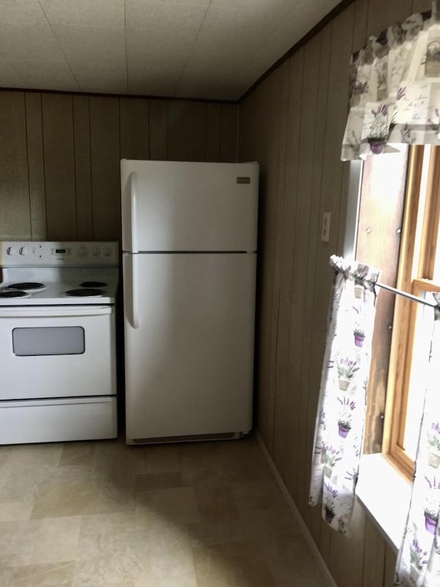 kitchen featuring wooden walls and white appliances