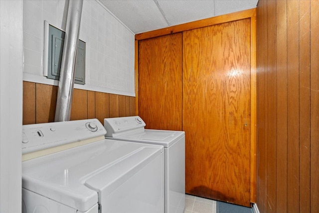 washroom featuring wood walls and washer and dryer