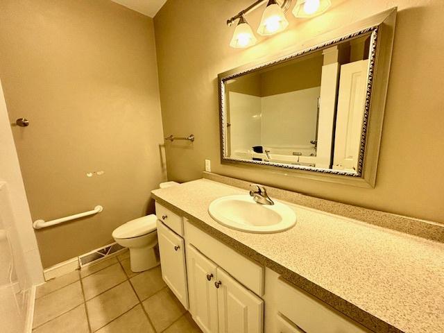 bathroom featuring tile patterned flooring, vanity, and toilet