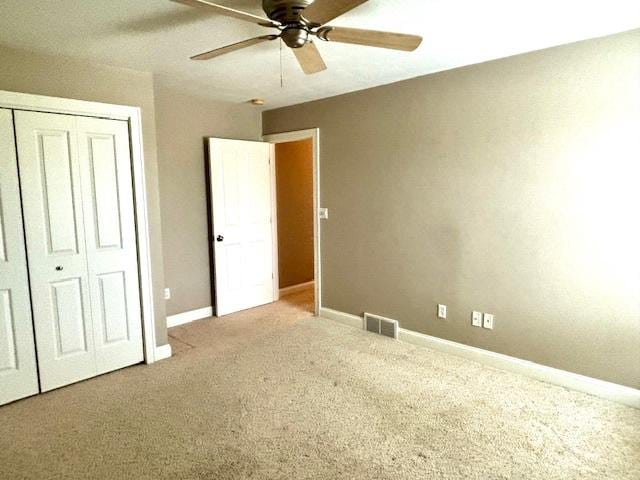 unfurnished bedroom with carpet flooring, ceiling fan, and a closet