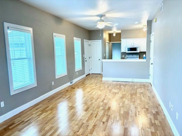 unfurnished living room with ceiling fan and light hardwood / wood-style flooring