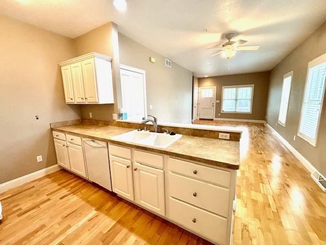 kitchen featuring white dishwasher, sink, light hardwood / wood-style flooring, ceiling fan, and white cabinetry