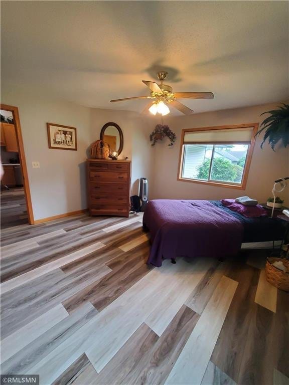 bedroom with light hardwood / wood-style floors and ceiling fan