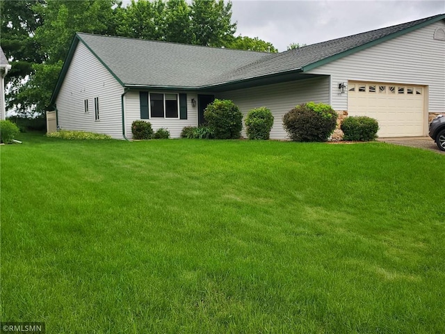 ranch-style home with a garage and a front lawn