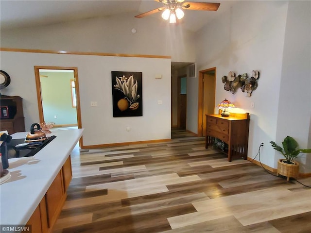 interior space with ceiling fan, light hardwood / wood-style flooring, and high vaulted ceiling